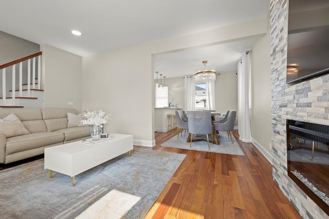 80-21 209th St, Hollis Hills, NY 11427 - living area featuring wood finished floors, stairway, an inviting chandelier, a fireplace, and baseboards