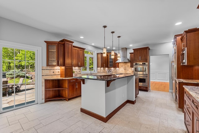 37 Shallow Stream Rd, Carmel, NY 10512 - kitchen with wall chimney exhaust hood, appliances with stainless steel finishes, stone tile flooring, decorative backsplash, and a breakfast bar