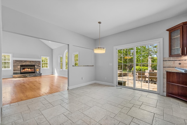37 Shallow Stream Rd, Carmel, NY 10512 - unfurnished dining area featuring baseboards, stone tile floors, lofted ceiling, and a stone fireplace
