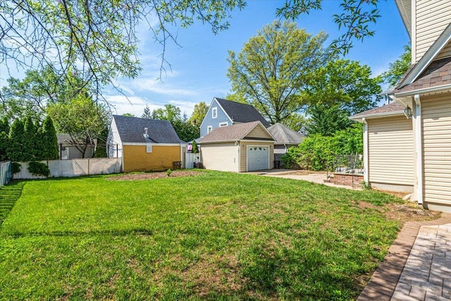 view of yard with concrete driveway, an outdoor structure, a garage, and fence