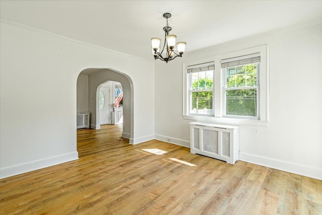 unfurnished dining area featuring a wealth of natural light, radiator heating unit, a chandelier, and crown molding