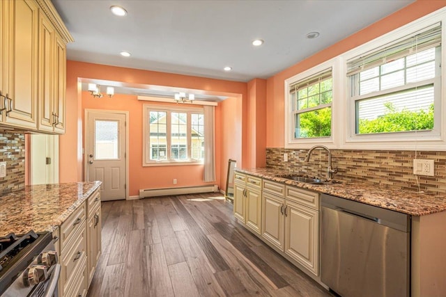 kitchen featuring a sink, stainless steel appliances, wood finished floors, cream cabinets, and baseboard heating