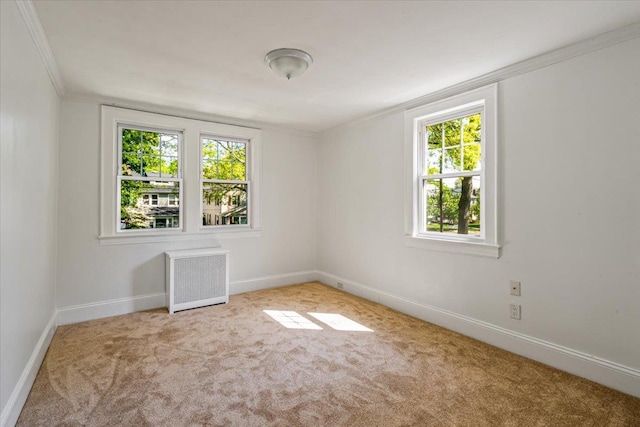 empty room with carpet, baseboards, ornamental molding, and radiator heating unit