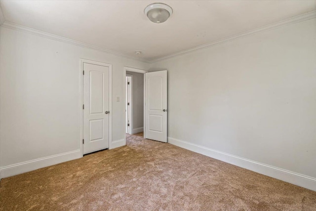 unfurnished bedroom featuring crown molding, carpet flooring, and baseboards