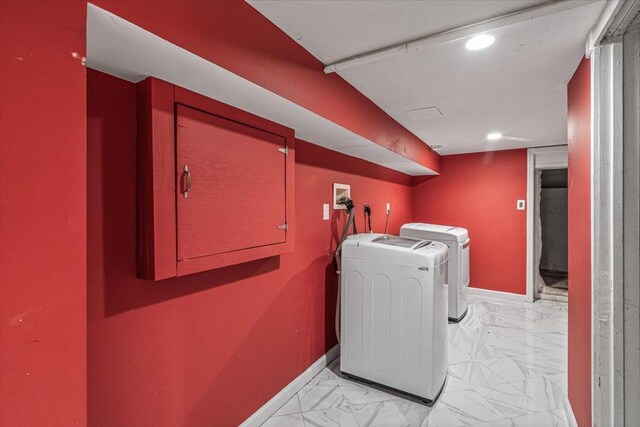 laundry room with washing machine and clothes dryer, marble finish floor, baseboards, and laundry area