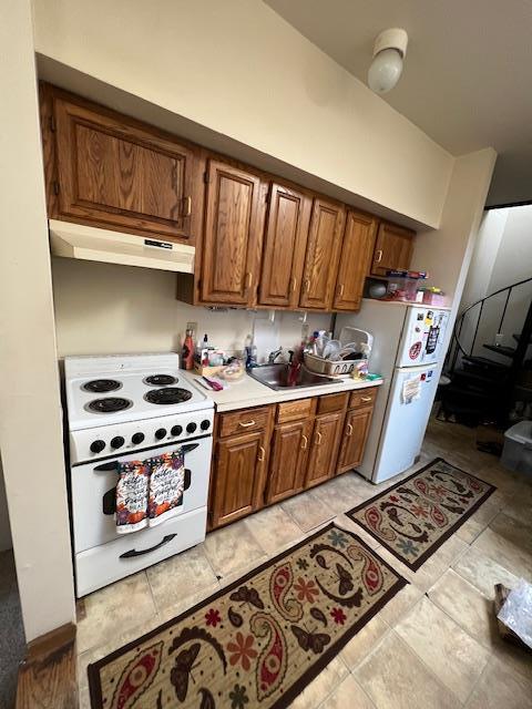 317 Elwood Ave, Hawthorne, NY 10532 - kitchen featuring a sink, brown cabinetry, white appliances, under cabinet range hood, and light countertops