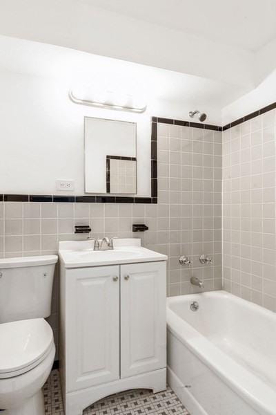 21-55 34th Ave Unit 3C, Long Island City, NY 11106 - bathroom with vanity, toilet, tile walls, washtub / shower combination, and tile patterned floors