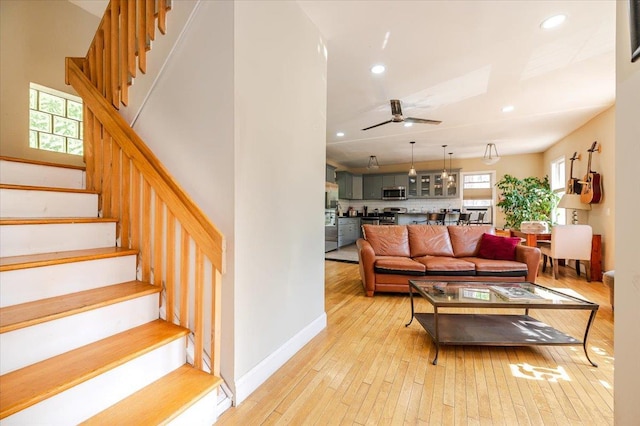 living room with stairway, plenty of natural light, and light wood-style floors