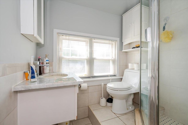 full bath with toilet, tile walls, vanity, tile patterned floors, and a shower stall