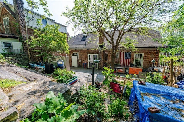 rear view of house featuring brick siding and a wooden deck