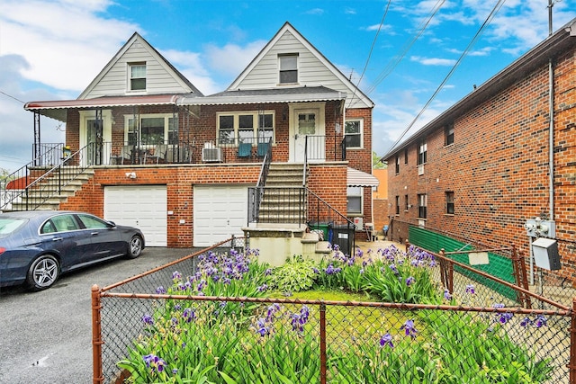 view of front of property featuring a porch, aphalt driveway, stairs, brick siding, and a garage