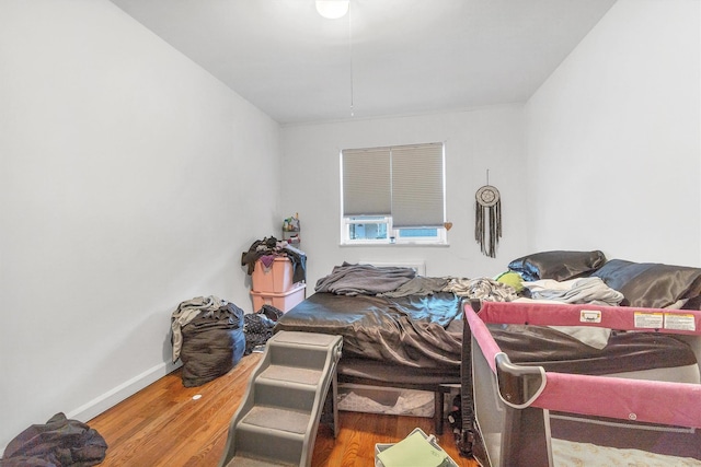 bedroom featuring baseboards and wood finished floors