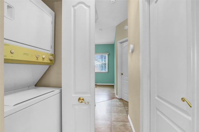 606 Narragansett Villas Dr Unit 606, Lindenhurst, NY 11757 - laundry area featuring stacked washer and clothes dryer, light tile patterned floors, and baseboards