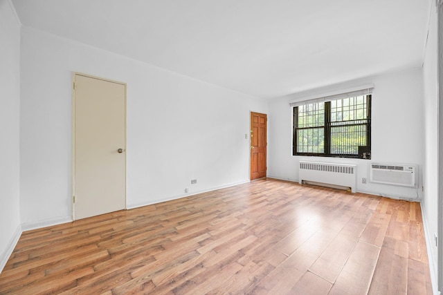 70-07 E Park Dr Unit A, Kew Garden Hills, NY 11367 - unfurnished room featuring radiator, light wood-style flooring, and a wall mounted AC