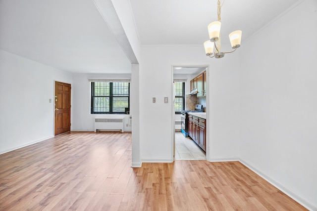 70-07 E Park Dr Unit A, Kew Garden Hills, NY 11367 - spare room with radiator heating unit, a chandelier, light wood finished floors, crown molding, and baseboards