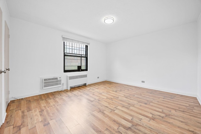 70-07 E Park Dr Unit A, Kew Garden Hills, NY 11367 - unfurnished room with radiator heating unit, light wood-style floors, and an AC wall unit