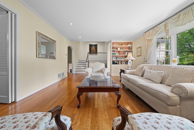 287 Old Army Rd, Scarsdale, NY 10583 - living room with arched walkways, wood finished floors, built in shelves, ornamental molding, and baseboards
