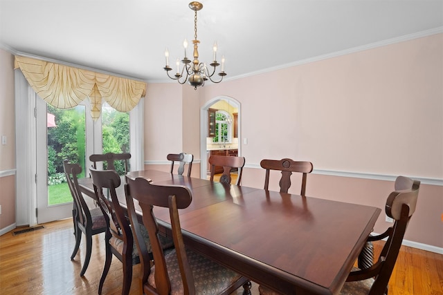 287 Old Army Rd, Scarsdale, NY 10583 - dining room featuring arched walkways, a chandelier, healthy amount of natural light, crown molding, and light wood finished floors
