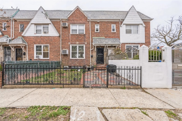 84-17 25th Ave, East Elmhurst, NY 11370 - townhome / multi-family property featuring a fenced front yard, brick siding, a wall unit AC, and a high end roof