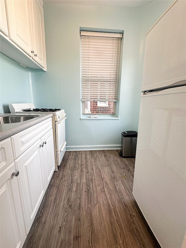 kitchen featuring white cabinetry, white appliances, dark wood-style floors, and baseboards