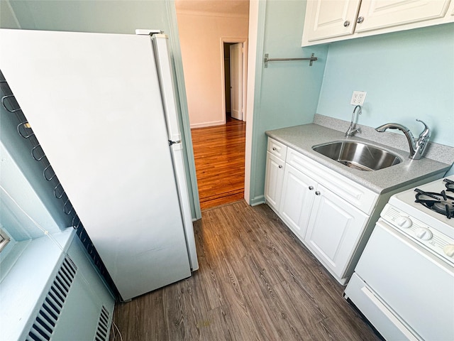 kitchen with freestanding refrigerator, dark wood-style flooring, range with gas stovetop, and a sink