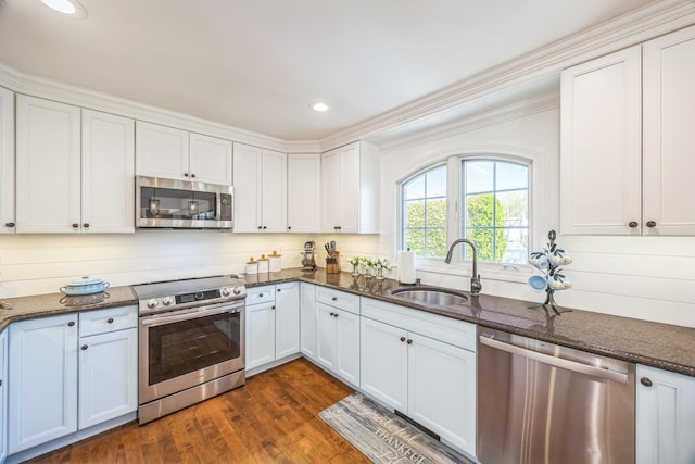 26 Forte Ave, Old Bethpage, NY 11804 - kitchen with stainless steel appliances, a sink, white cabinets, dark stone countertops, and crown molding