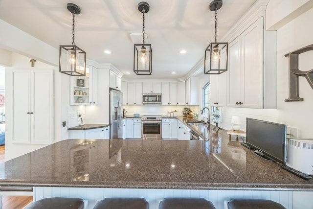 26 Forte Ave, Old Bethpage, NY 11804 - kitchen with appliances with stainless steel finishes, a sink, a peninsula, white cabinets, and a kitchen breakfast bar