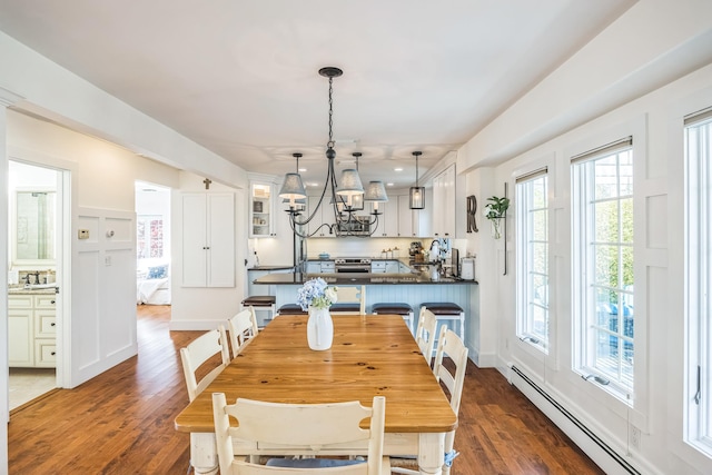 26 Forte Ave, Old Bethpage, NY 11804 - dining space with a baseboard heating unit, dark wood-style floors, and a chandelier
