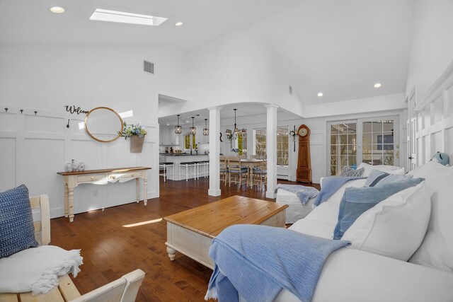 26 Forte Ave, Old Bethpage, NY 11804 - living area with ornate columns, wood finished floors, a decorative wall, recessed lighting, and high vaulted ceiling