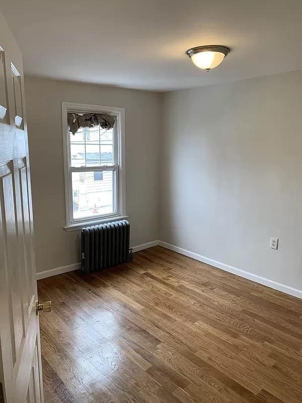 4565 Matilda Ave, Bronx, NY 10470 - empty room with baseboards, radiator, and wood finished floors