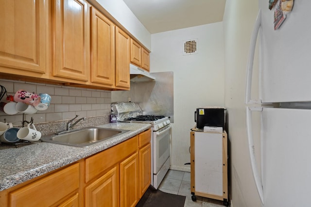 kitchen featuring white appliances, a sink, under cabinet range hood, and decorative backsplash