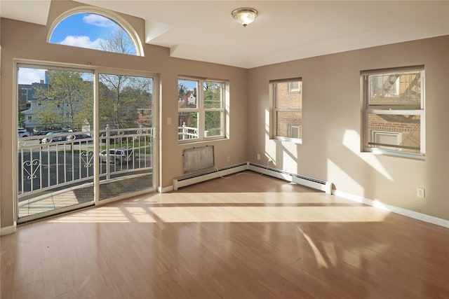 interior space featuring wood finished floors, baseboards, and a healthy amount of sunlight