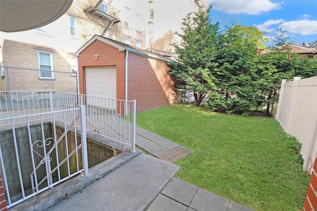 view of yard featuring concrete driveway, an outbuilding, a fenced backyard, and a detached garage