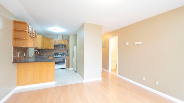 14322 Beech Ave, Flushing, NY 11355 - kitchen featuring gas stove, under cabinet range hood, open shelves, freestanding refrigerator, and decorative backsplash