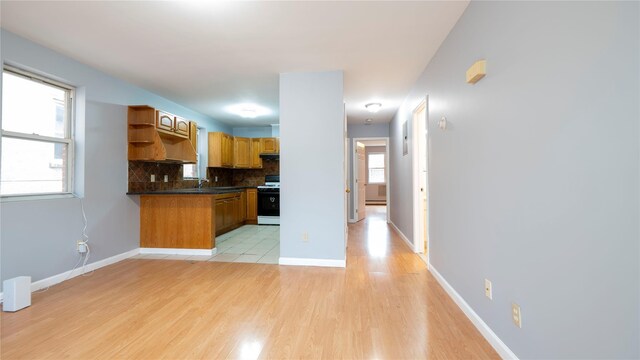 14322 Beech Ave, Flushing, NY 11355 - kitchen with open shelves, dark countertops, white range with gas stovetop, backsplash, and light wood-style floors