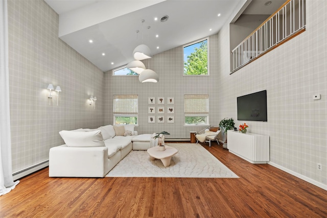 10 Spectrum Dr, Chester, NY 10918 - living room featuring high vaulted ceiling, wood finished floors, a baseboard radiator, wallpapered walls, and baseboards