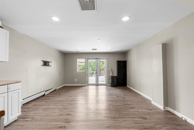 10 Spectrum Dr, Chester, NY 10918 - unfurnished living room featuring baseboard heating, light wood-type flooring, recessed lighting, baseboards, and french doors