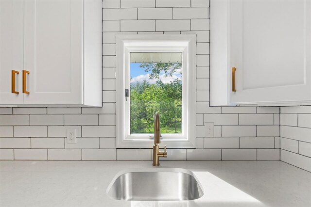 315 Scotchtown Rd, Goshen, NY 10924 - kitchen view of a sink, decorative backsplash, white cabinetry, and light stone countertops