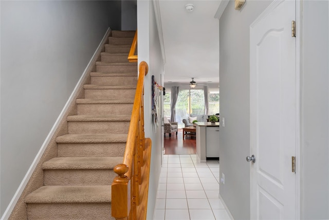 staircase featuring ceiling fan, baseboards, and tile patterned floors
