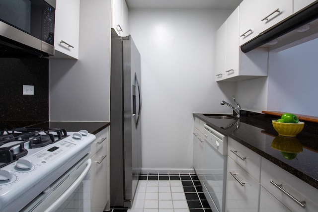 2373 Broadway Unit 602, New York Manhattan, NY 10024 - kitchen featuring appliances with stainless steel finishes, a sink, white cabinets, tile patterned floors, and dark stone countertops