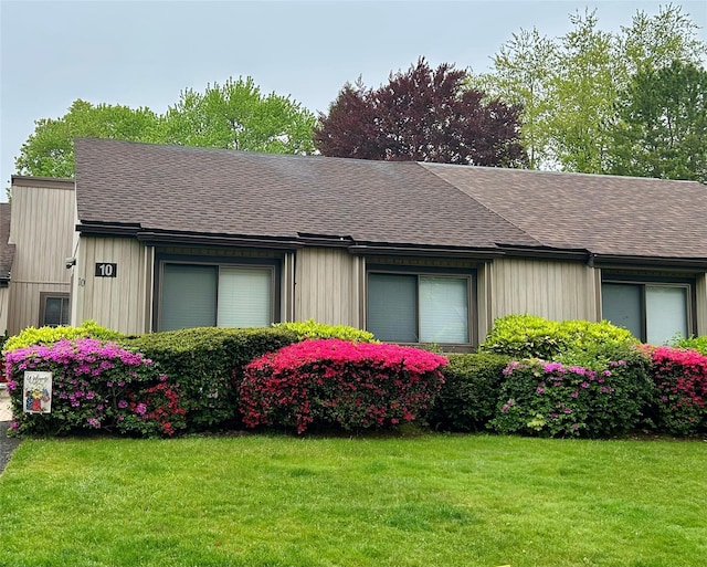 view of home's exterior featuring a yard and a shingled roof