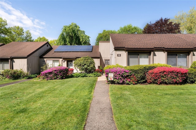 10 Strathmore Gate Dr, Stony Brook, NY 11790 - mid-century home featuring a front yard, solar panels, and roof with shingles