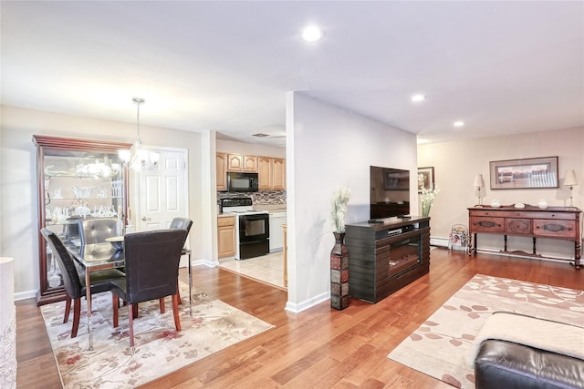 dining area featuring light wood finished floors, a chandelier, recessed lighting, and baseboards