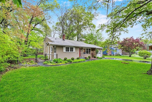view of front of property featuring a chimney, driveway, and a garage