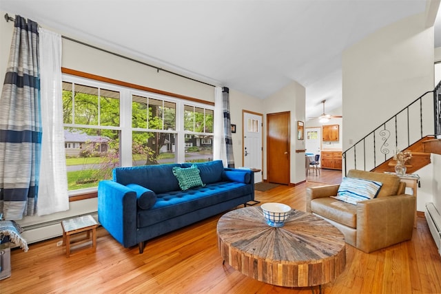 living room featuring wood finished floors, a ceiling fan, and stairs