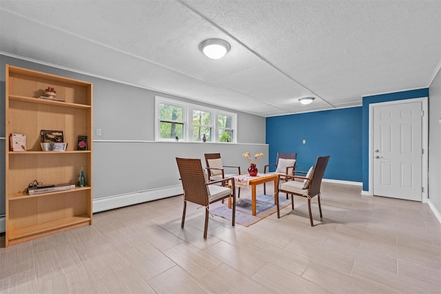 dining area featuring baseboard heating, a textured ceiling, and baseboards