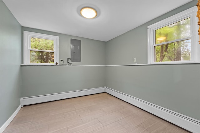 spare room featuring electric panel, baseboards, and a baseboard heating unit