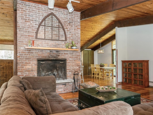living room featuring wood ceiling, wood-type flooring, beamed ceiling, and a fireplace