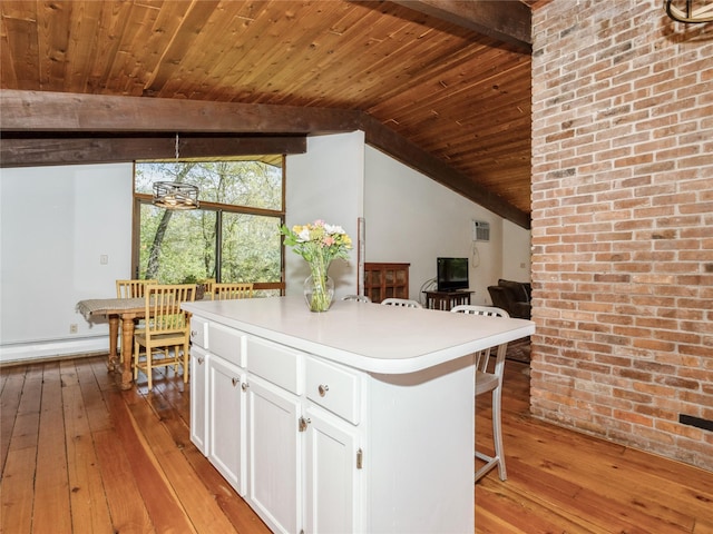 kitchen with a baseboard radiator, light wood-style floors, wood ceiling, white cabinets, and a breakfast bar area
