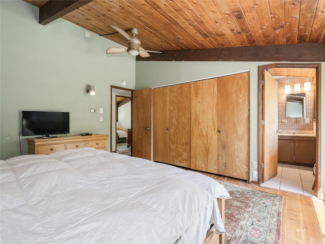 bedroom featuring wooden ceiling, wood finished floors, a closet, a sink, and ensuite bathroom